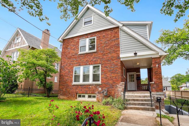 a view of a brick house with a yard and plants