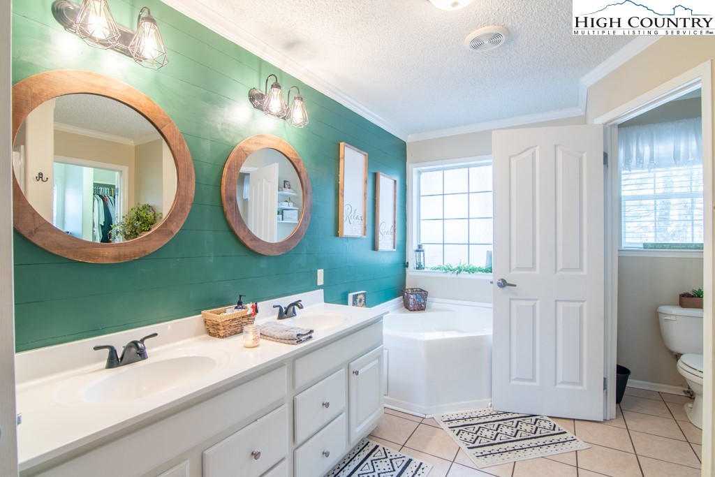 8877 Glade Valley Road Ennice, NC 28623 - Photo 11 of 49 a bathroom with a double vanity sink and a mirror