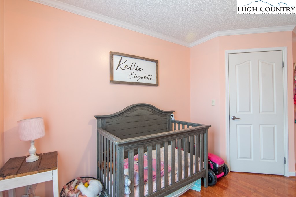 8877 Glade Valley Road Ennice, NC 28623 - Photo 19 of 49 a bedroom with a bed and wooden floor