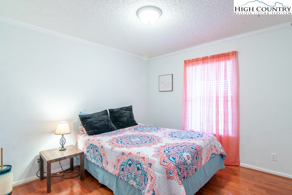 8877 Glade Valley Road Ennice, NC 28623 - Photo 21 of 49 a bedroom with a bed and wooden floor