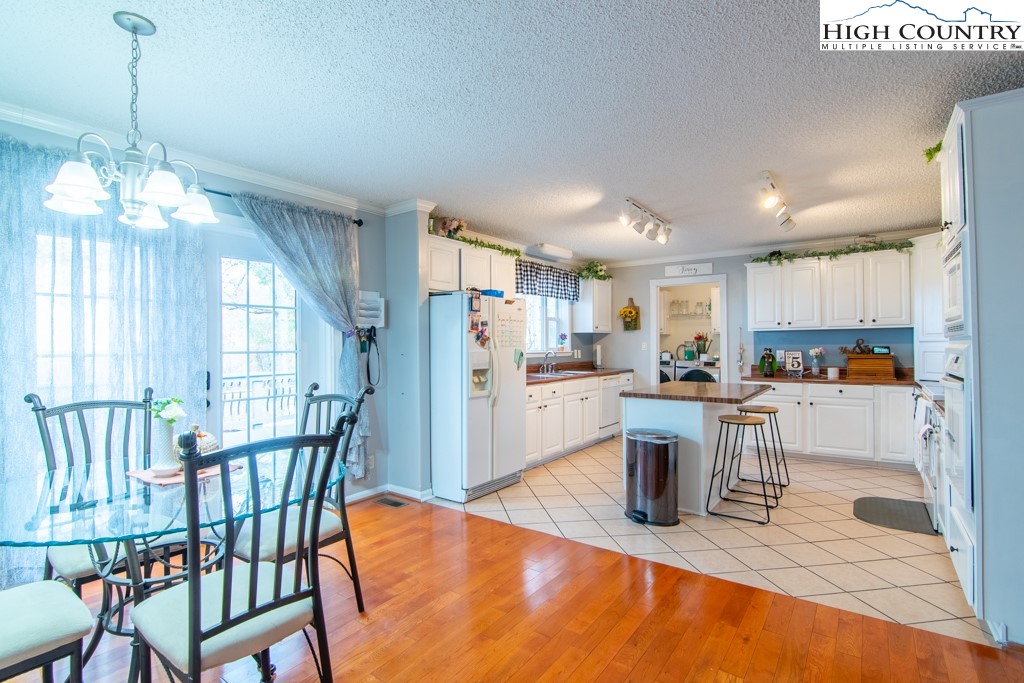 8877 Glade Valley Road Ennice, NC 28623 - Photo 25 of 49 a kitchen with a dining table chairs and refrigerator