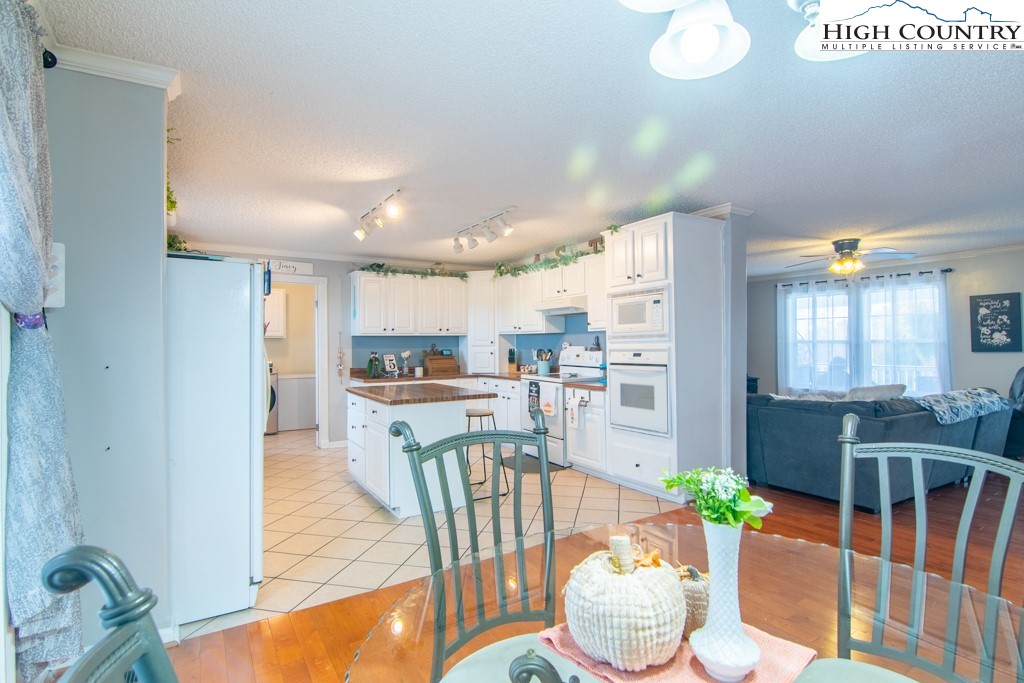 8877 Glade Valley Road Ennice, NC 28623 - Photo 26 of 49 a kitchen with stainless steel appliances wooden floor dining table and chairs