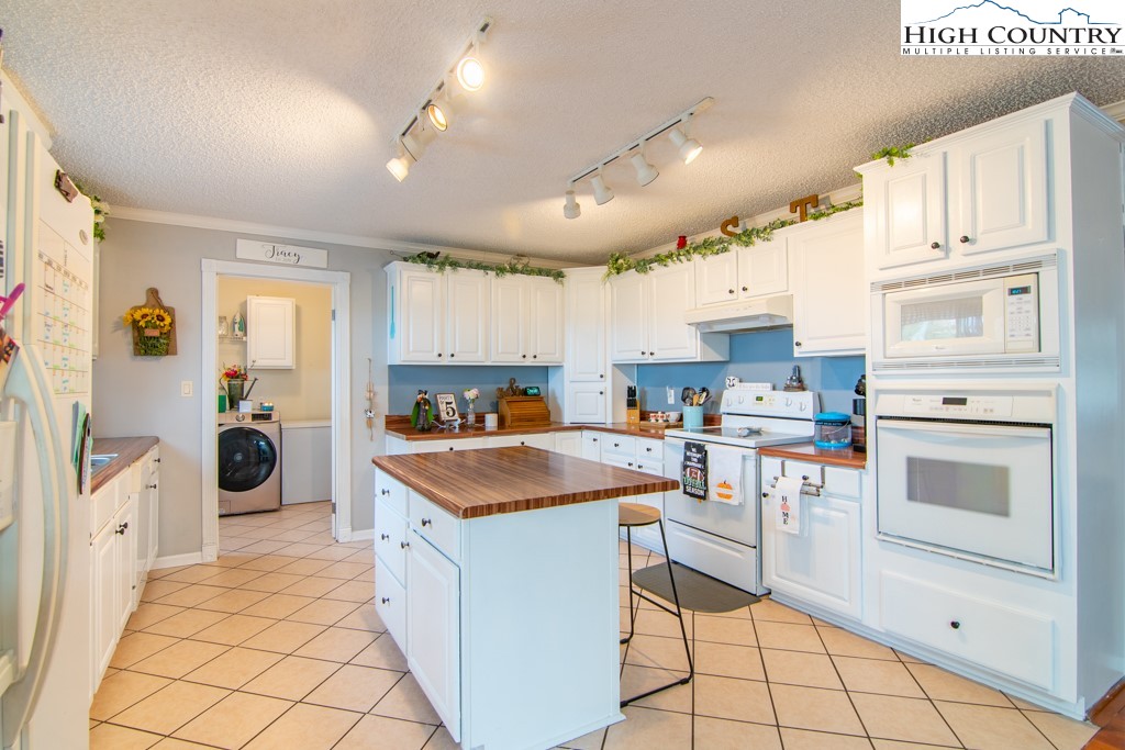 8877 Glade Valley Road Ennice, NC 28623 - Photo 27 of 49 a kitchen with white cabinets and white appliances