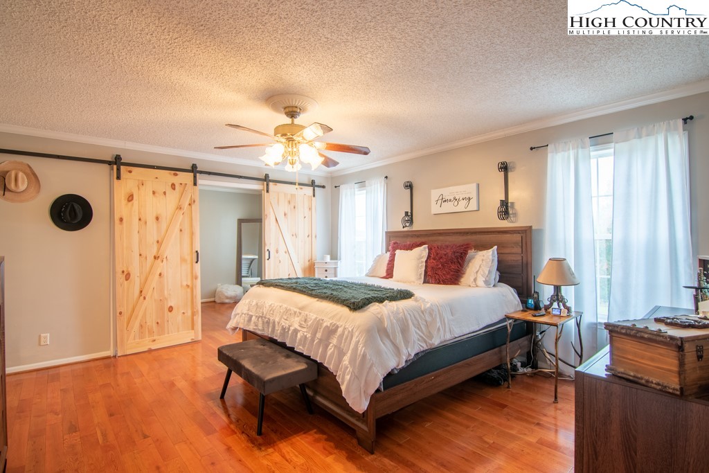 8877 Glade Valley Road Ennice, NC 28623 - Photo 6 of 49 a bedroom with a bed and a chandelier