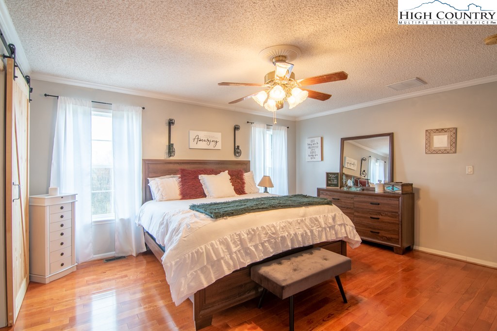 8877 Glade Valley Road Ennice, NC 28623 - Photo 7 of 49 a bedroom with a bed chandelier and a window