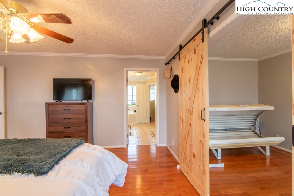 8877 Glade Valley Road Ennice, NC 28623 - Photo 8 of 49 a bedroom with a bed and wooden floor