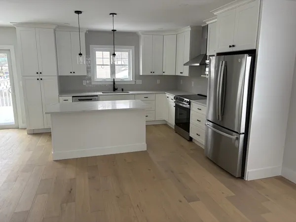 a kitchen with appliances a sink and a refrigerator