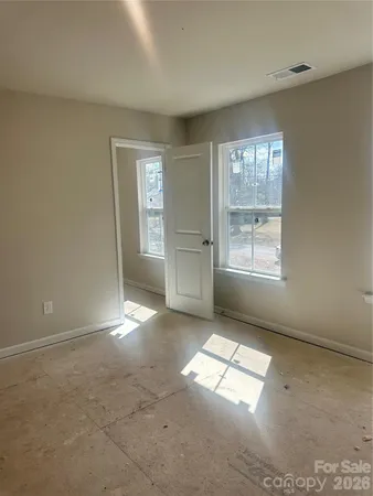 an empty room with windows and cabinet