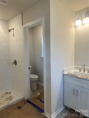 a bathroom with a granite countertop toilet sink and mirror
