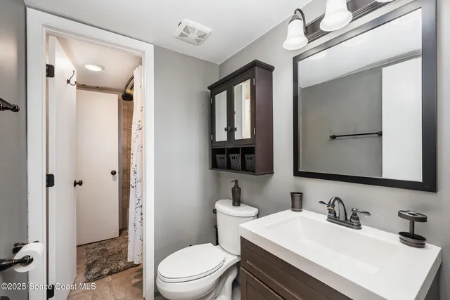 a bathroom with a sink vanity mirror and toilet