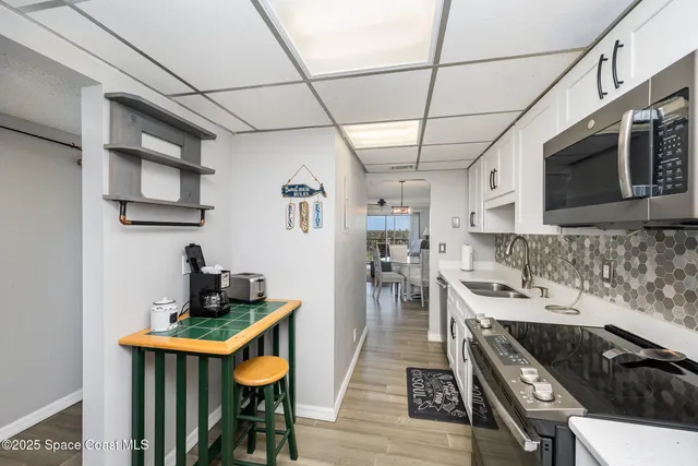 a kitchen with stainless steel appliances granite countertop a stove a sink dishwasher and cabinets with wooden floor