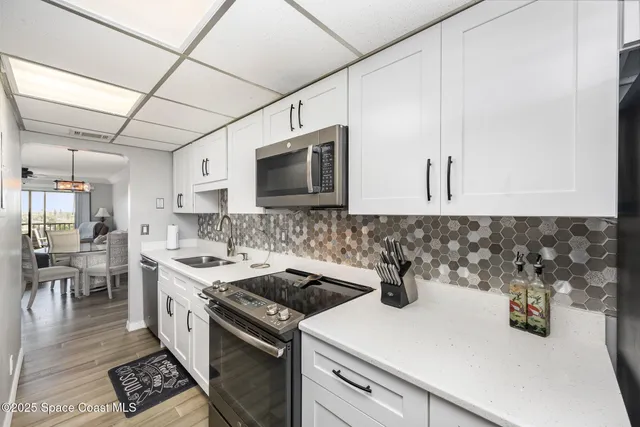 a kitchen with a sink a stove and cabinets