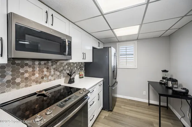 a kitchen with stainless steel appliances granite countertop a stove a microwave and a wooden cabinets