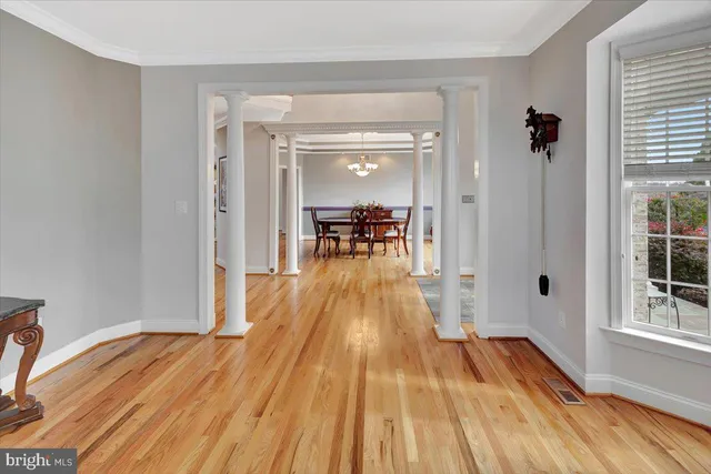 a dining room with wooden floor a chandelier a wooden table and chairs