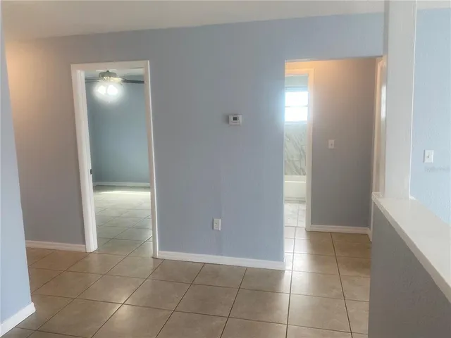 a view of an empty room with closet and a bathroom