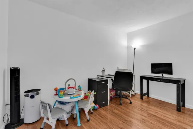 a view of a workspace with furniture and a flat screen tv