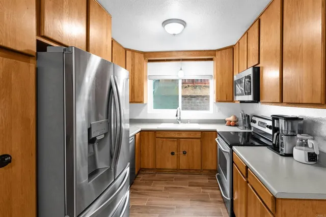 a kitchen with stainless steel appliances granite countertop a refrigerator a sink a stove and island