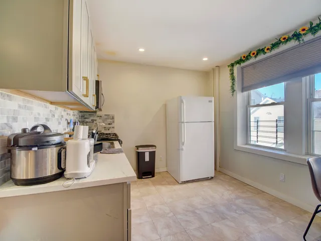 a view of a kitchen with a stove fridge and wooden floor