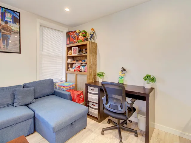 a living room with furniture a rug and a wall painting