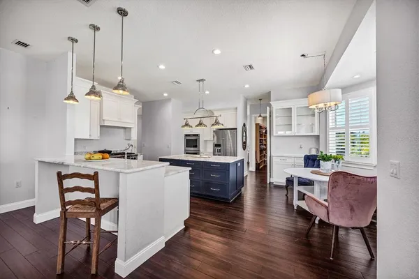 a kitchen with a sink a counter top space stainless steel appliances and wooden floor