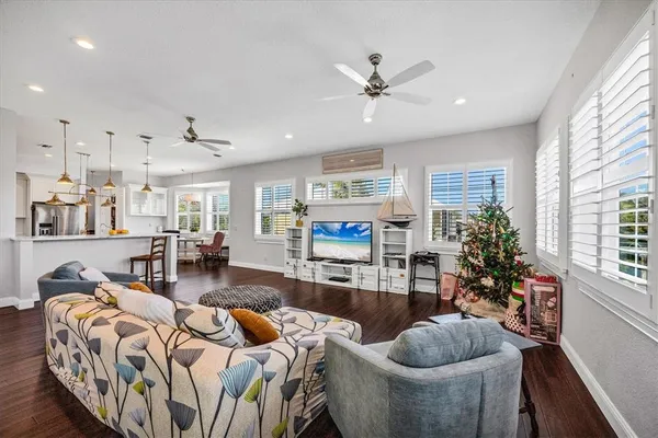 a living room with furniture floor to ceiling window and wooden floor