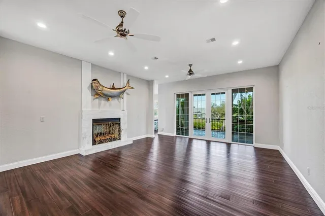 a view of a livingroom with wooden floor and a kitchen