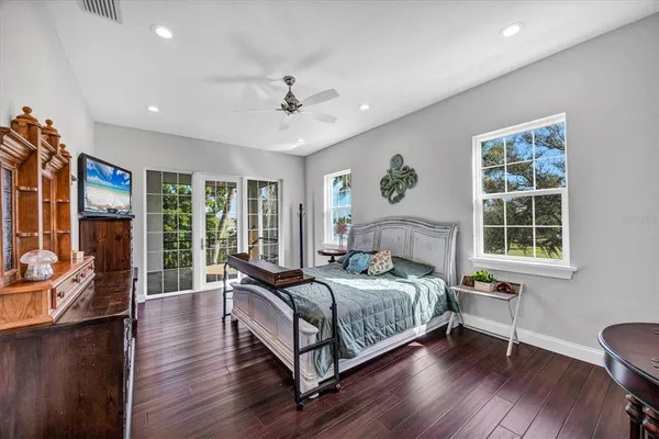 a bedroom with a bed wooden floor and window