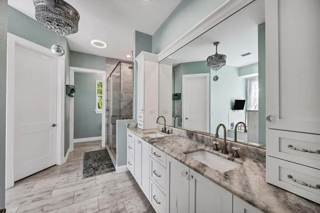 a bathroom with a granite countertop sink mirror vanity and a bathtub