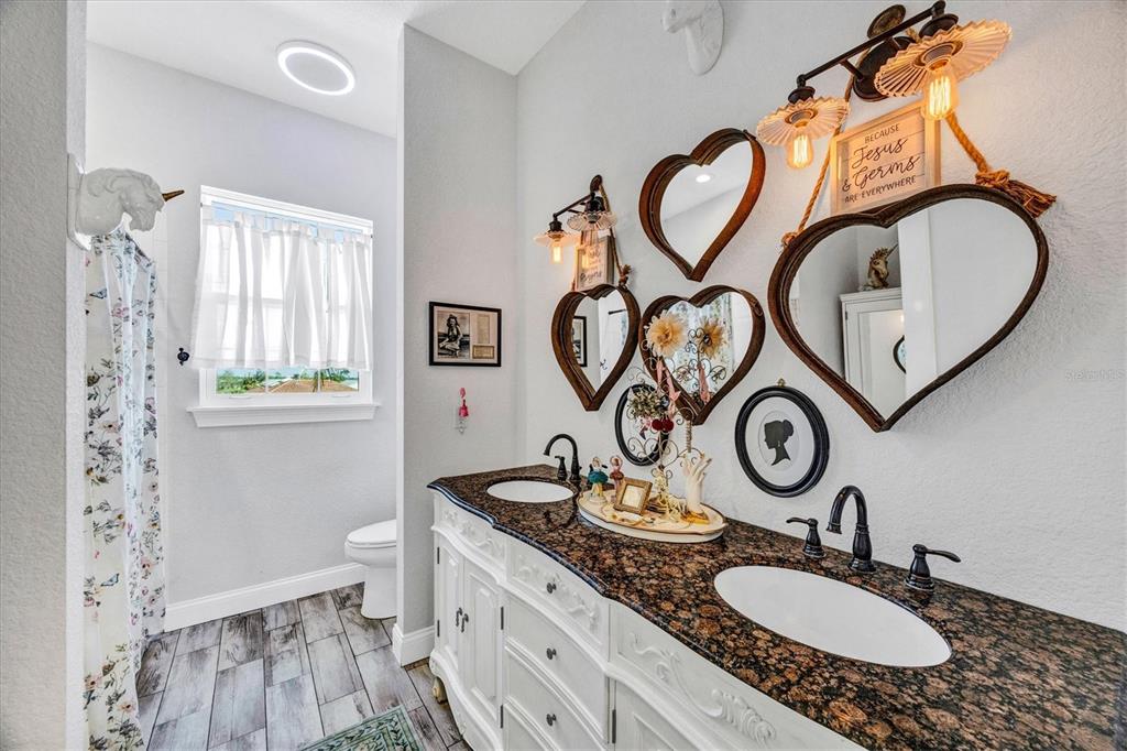 10050 Creekside Drive Placida, FL 33946 - Photo 34 of 52 a bathroom with a granite countertop sink and a mirror