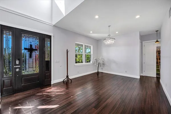 a view of a livingroom with furniture wooden floor chandelier and windows