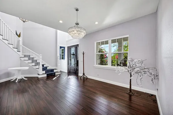 a kitchen with stainless steel appliances a stove a sink dishwasher a refrigerator white cabinets and wooden floor next to a window