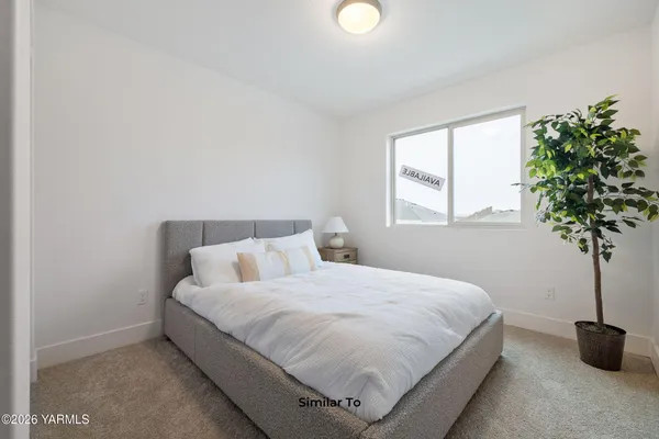 a bedroom with a bed and a potted plant