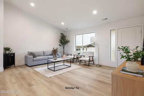 a living room with furniture and a potted plant