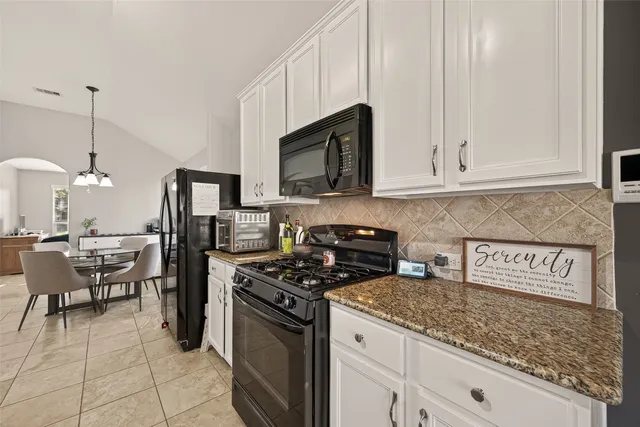 a living room with furniture kitchen view and a flat screen tv
