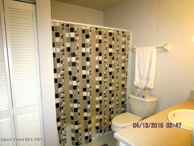1595 Dawes Road Northeast Palm Bay, FL 32905 - Photo 14 of 20 a white toilet sitting next to a shower curtain