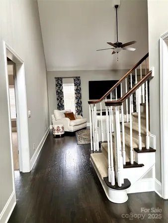 a view of a livingroom with wooden floor and staircase