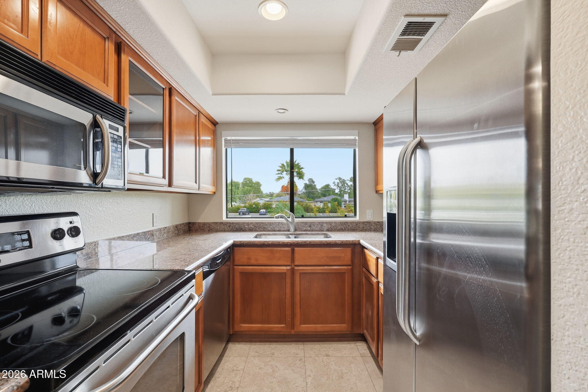 3235 East Camelback Road, Unit 211 Phoenix, AZ 85018 - Photo 3 of 17 a kitchen with stainless steel appliances granite countertop a sink stove and refrigerator