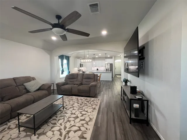 a living room with furniture and a wooden floor