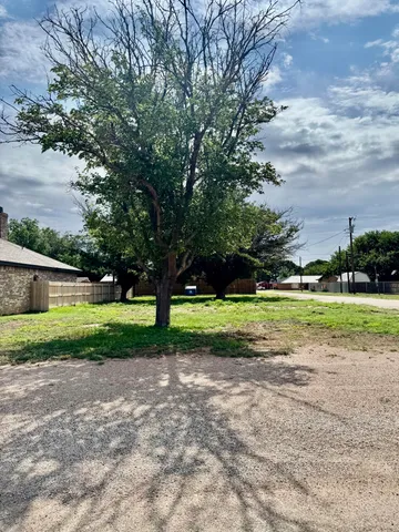 a view of a house with a big yard and large trees