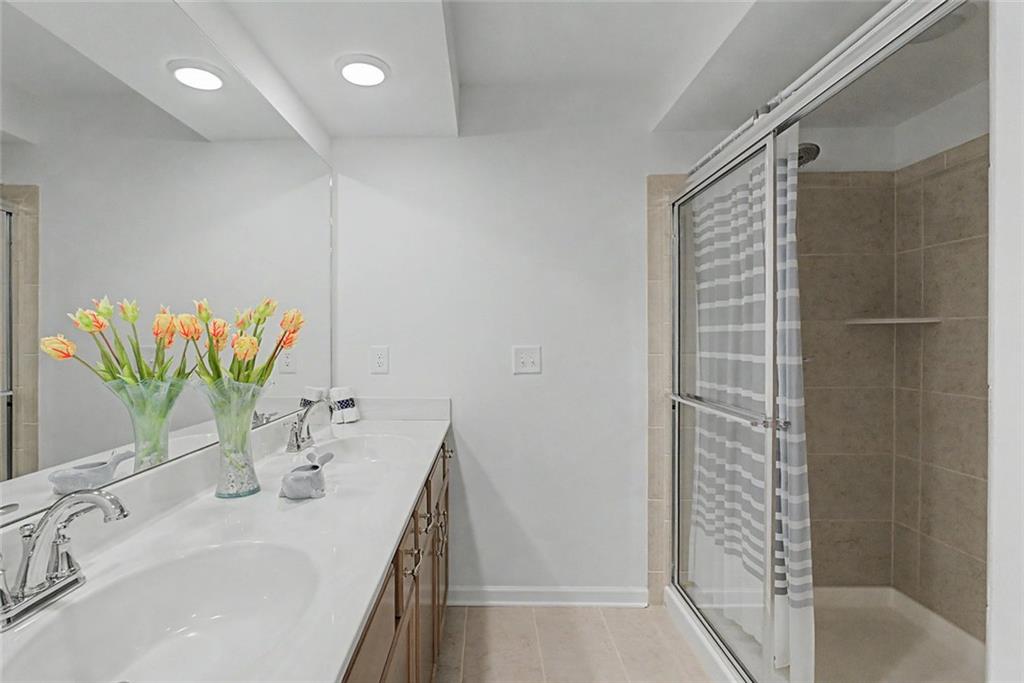 2310 Portrush Way Southeast Atlanta, GA 30339 - Photo 30 of 38 a bathroom with a granite countertop sink a mirror and shower