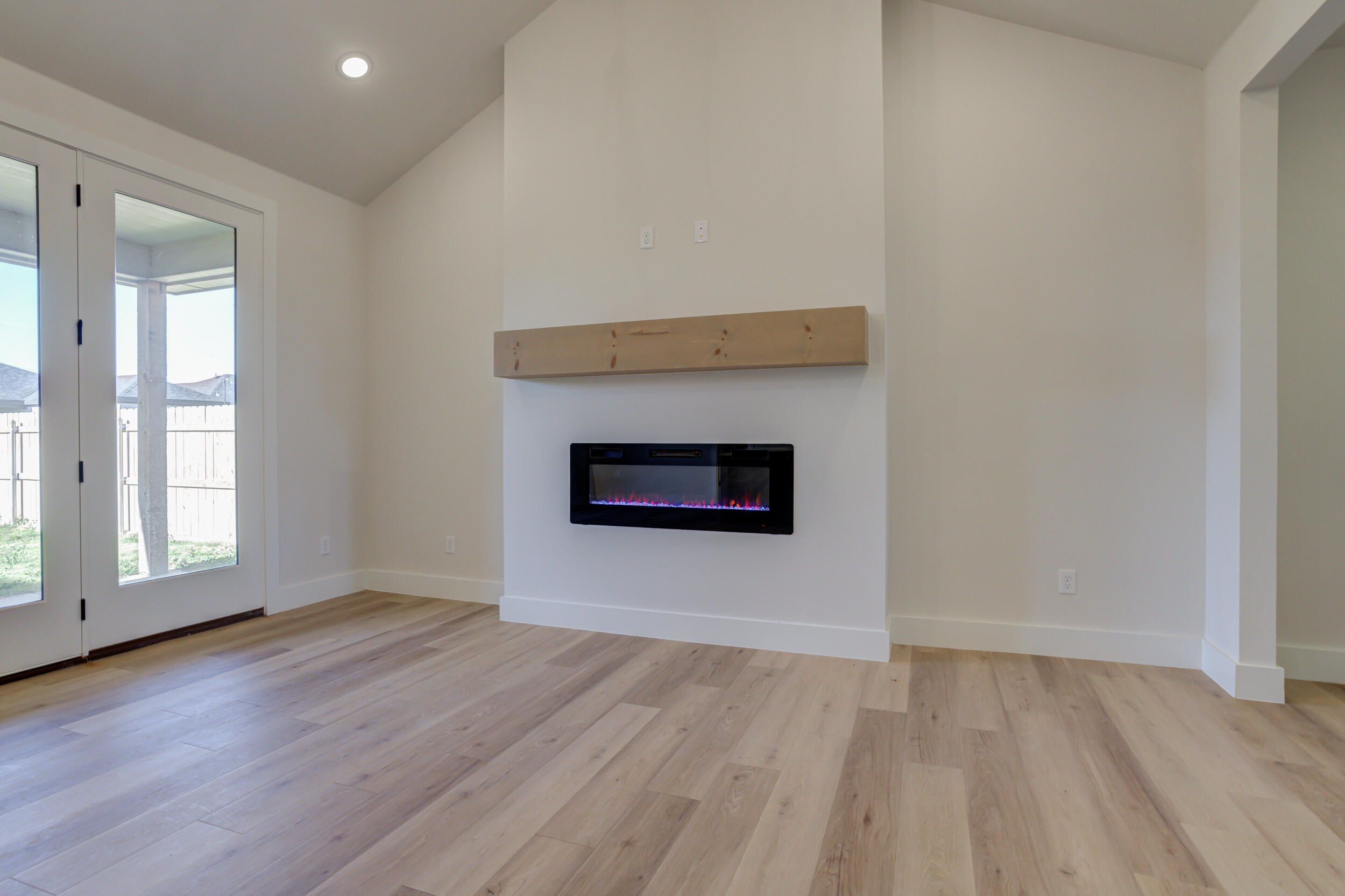 6913 13th Street Lubbock, TX 79416 - Photo 12 of 45 an empty room with wooden floor and windows