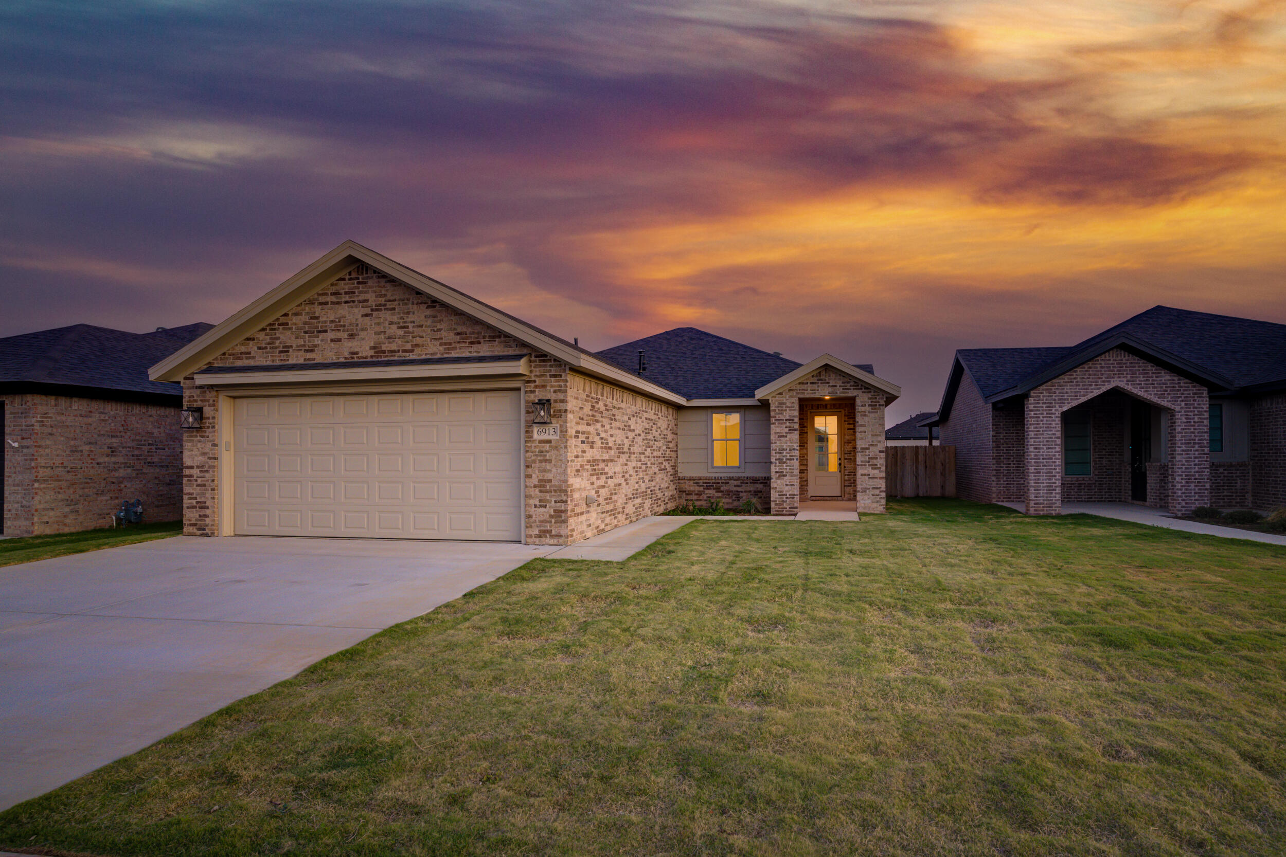 6913 13th Street Lubbock, TX 79416 - Photo 2 of 45 a front view of a house with a yard and garage