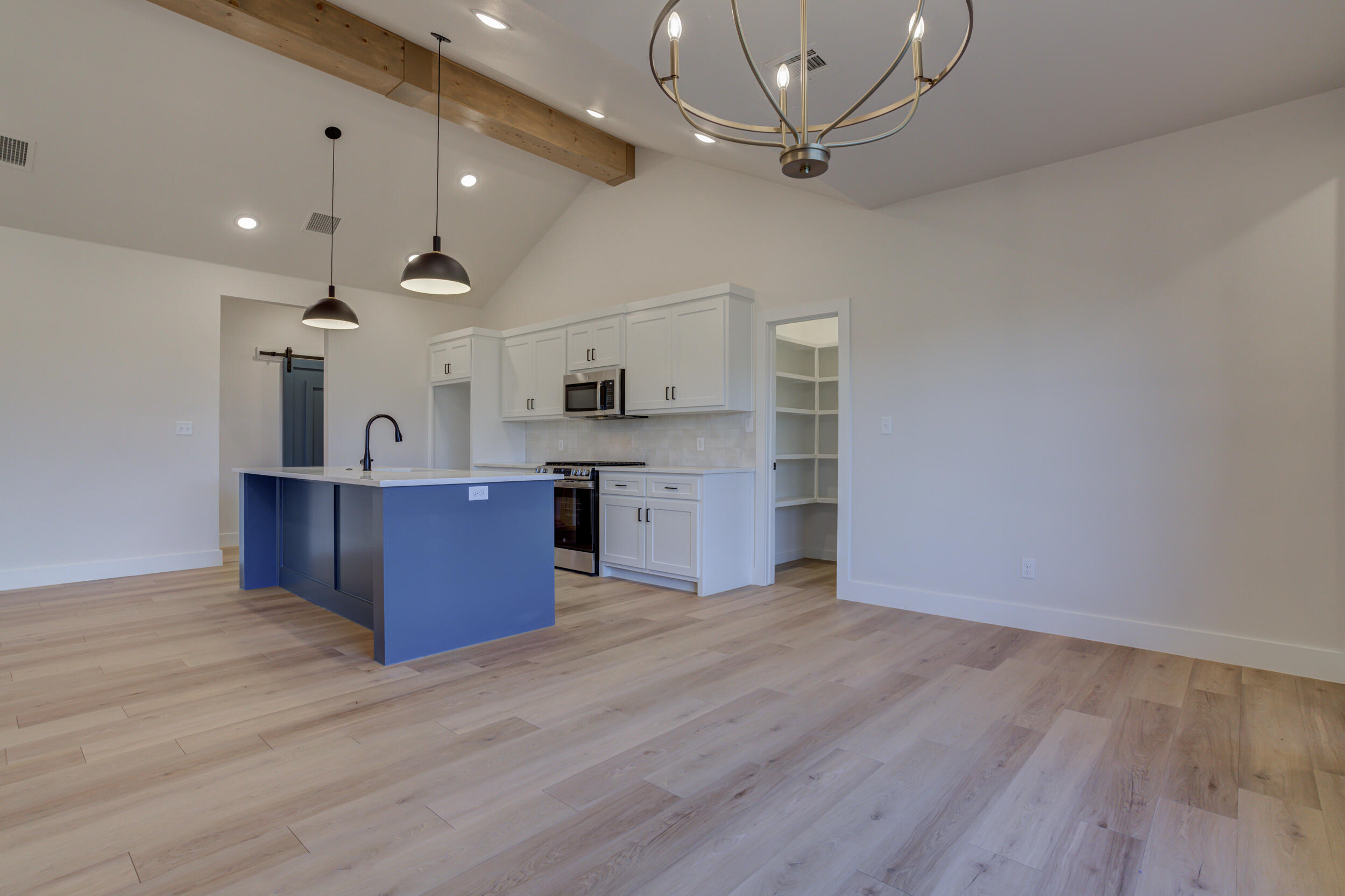 6913 13th Street Lubbock, TX 79416 - Photo 23 of 45 a large kitchen with stainless steel appliances granite countertop a stove cabinets and wooden floor