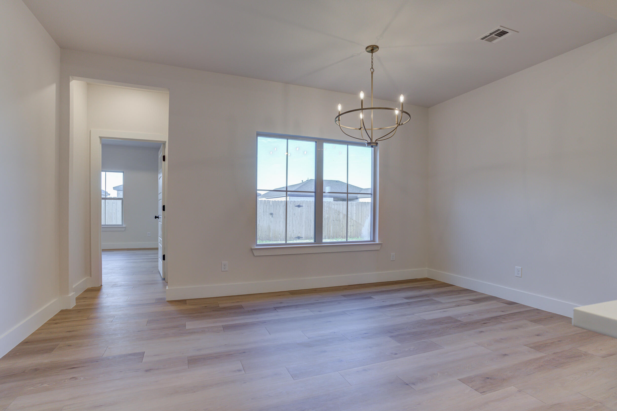 6913 13th Street Lubbock, TX 79416 - Photo 24 of 45 an empty room with wooden floor and windows