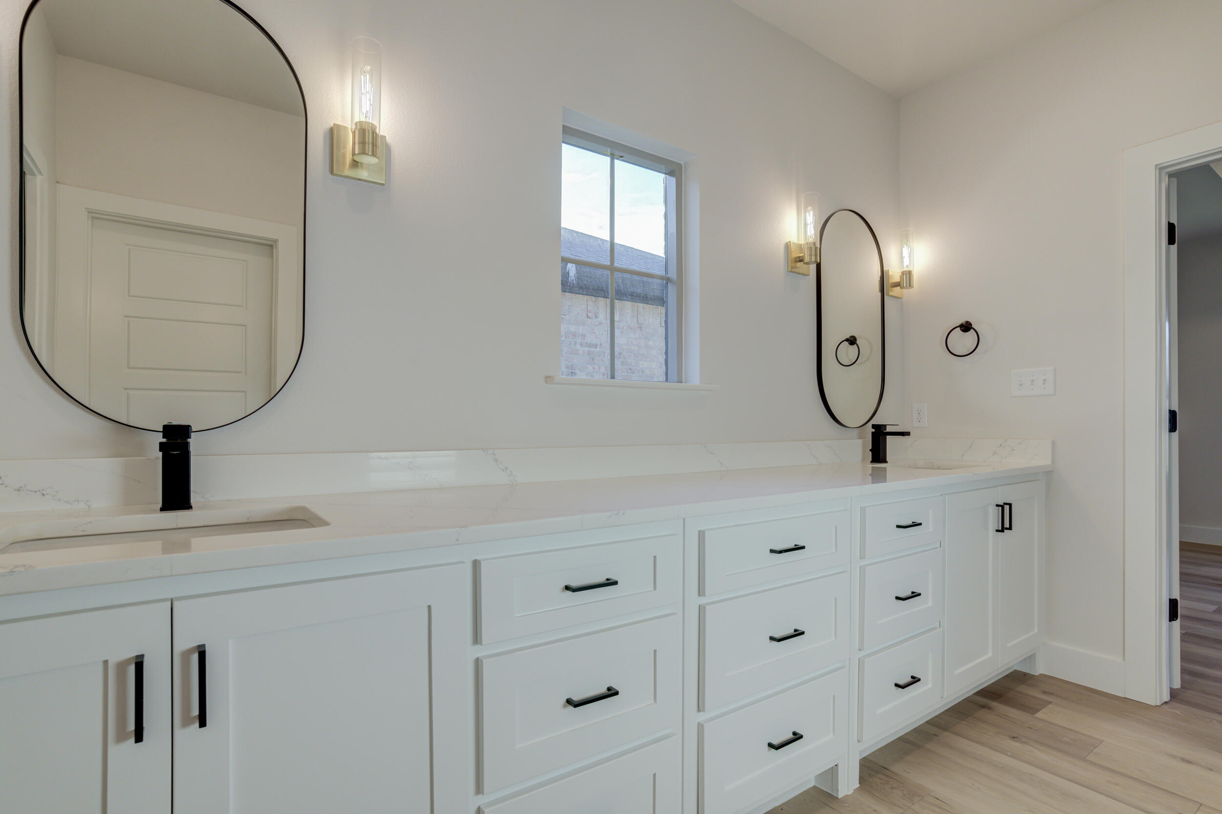 6913 13th Street Lubbock, TX 79416 - Photo 31 of 45 a bathroom with double vanity a sink a vanity a lamp and a mirror