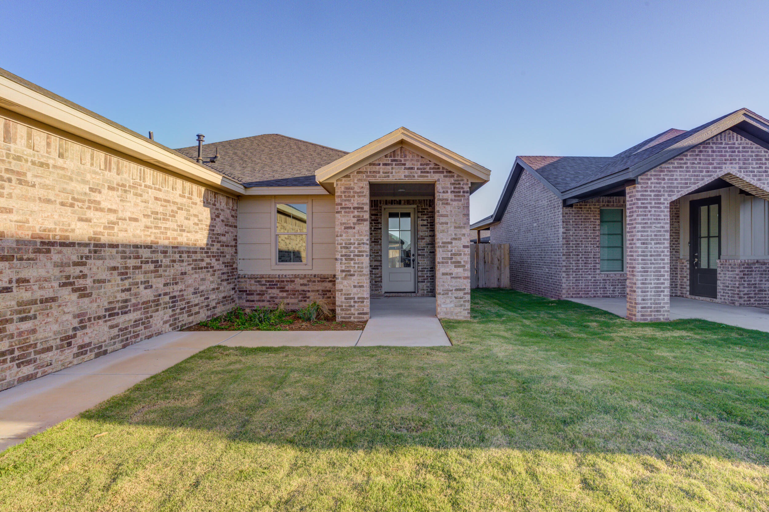 6913 13th Street Lubbock, TX 79416 - Photo 4 of 45 a front view of a house with a yard and garage