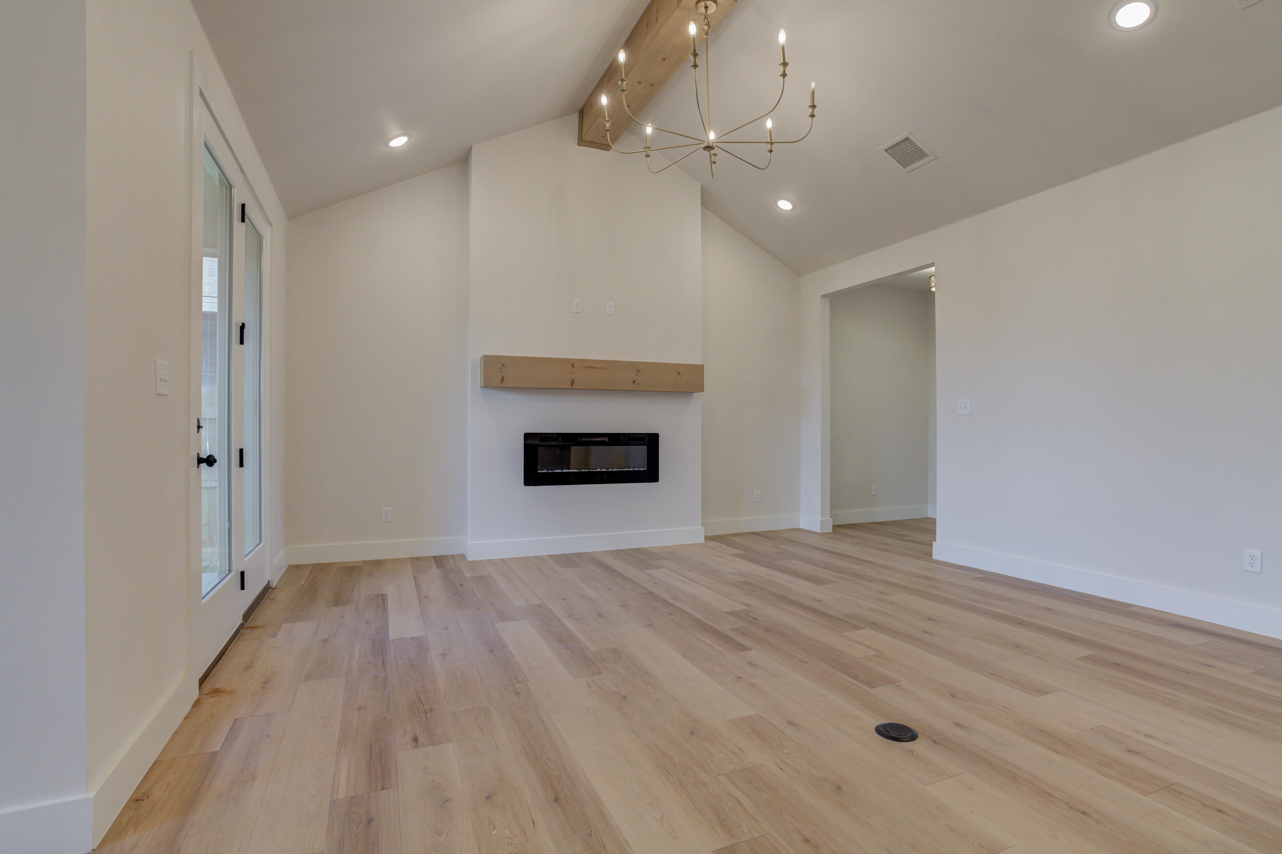 6913 13th Street Lubbock, TX 79416 - Photo 8 of 45 wooden floor in an empty room with a fireplace