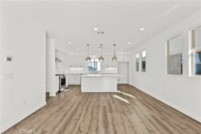 a very nice looking kitchen with granite countertop a sink cabinets and wooden floor