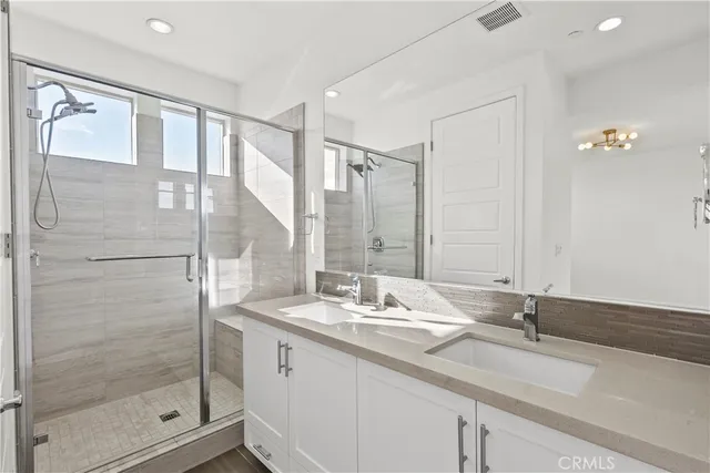 a bathroom with a shower sink and mirror