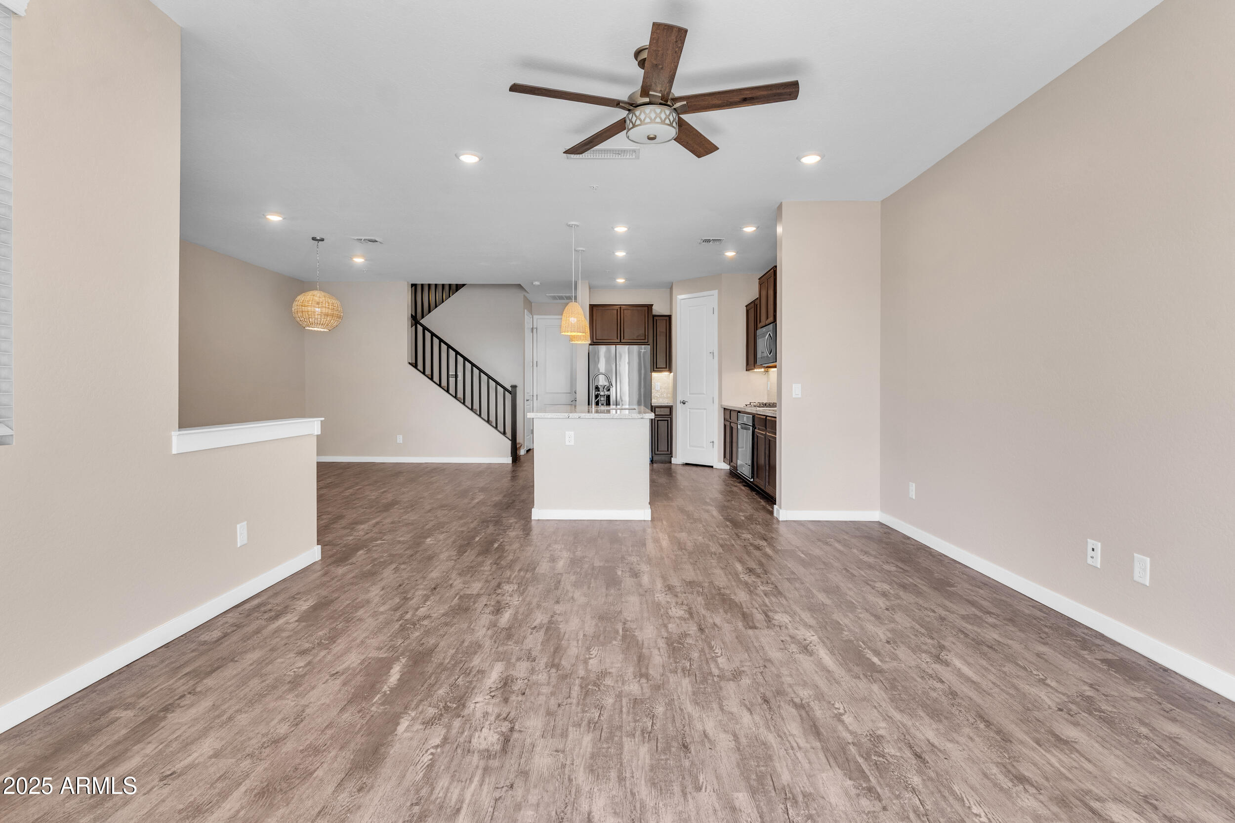 3855 South McQueen Road, Unit 98 Chandler, AZ 85286 - Photo 6 of 41 a view of empty room with wooden floor and a ceiling fan